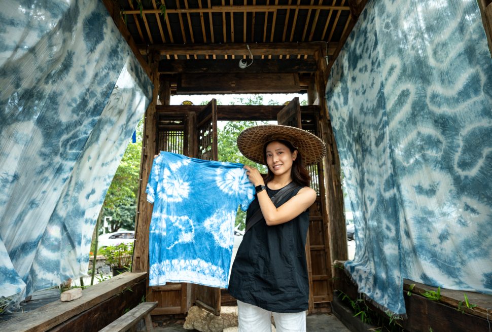 Smiling tourist showing off self-made tie-dye artwork in Yunnan