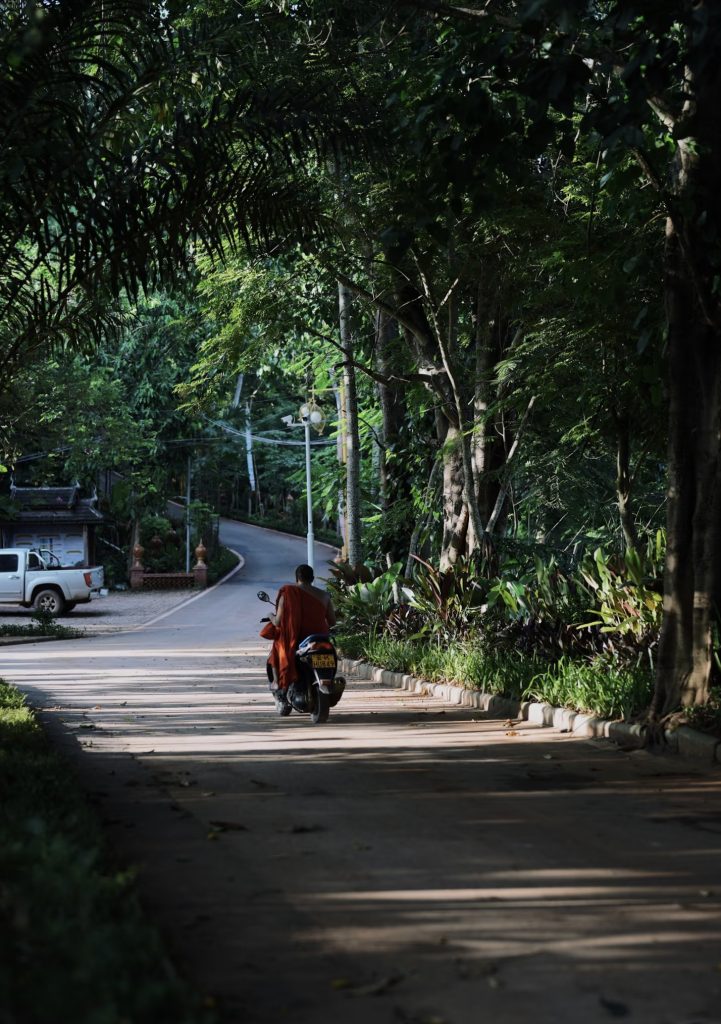 Local resident riding motorbike on country road in Manyuan Village Xishuangbanna Yunnan