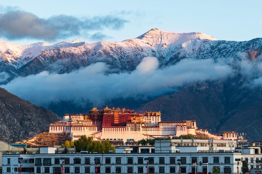 Sacred Potala Palace at the foot of snow mountains in Tibet